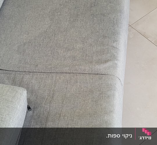 ספה אפורה עם כתמי לכלוך נראים לעין